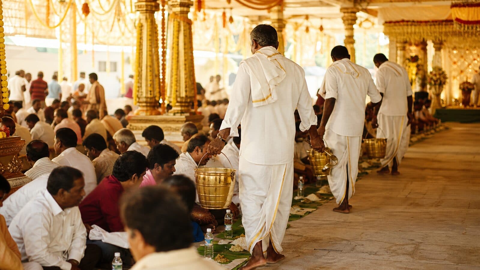 Wedding bhojanam — VS Caterers servers walking a banana-leaf line